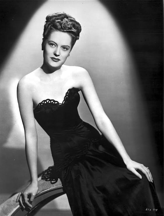 Alexis Smith sitting and wearing a Black Dress Photo Print (8 x 10)